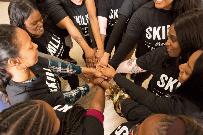 Participants from the West Philadelphia Skills Initiative gather in a circle with their hands together