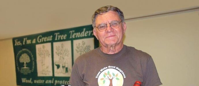 Community member Mike Hardy holds a bucket of tree care tools