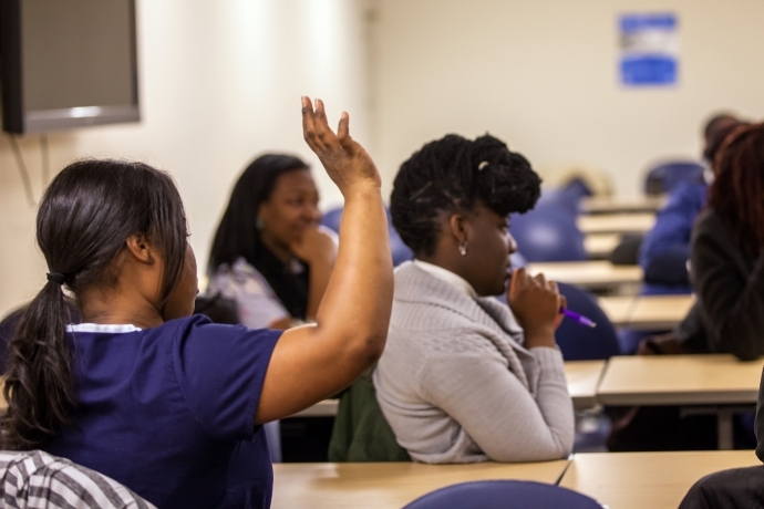 Participant in a workshop raises her hand