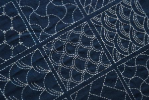 Traditional japanese sashiko mending done with white string on indigo fabric