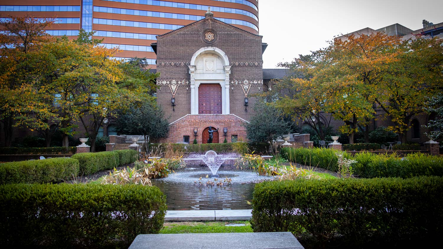 Image of the garden on Penn’s campus. Lush trees and bushes are set around a flowing water fountain