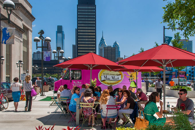 People enjoying lunch from a food truck at the Porch at 30th Street Station