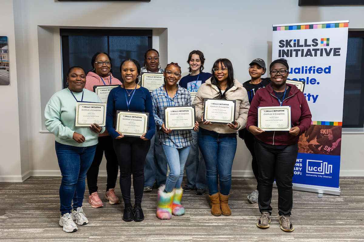 Skills Initiative graduates holding certificates during a closing session