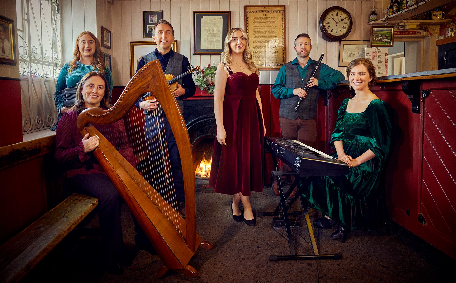 A group of performers in a grand room/ they carry large instruments