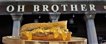 Image of a philly cheesesteak in front of Oh Brother