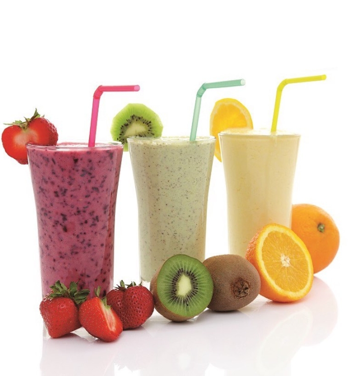 Three smoothies of different varieties surrounded by sliced fruit against a white background.